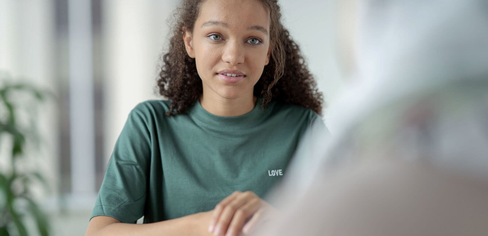Mental health and wellbeing. Young person discussing mental health with another person