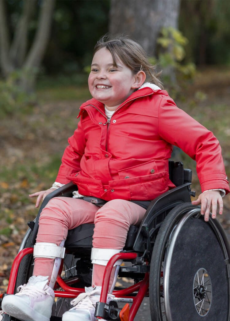 Child with arms in the air and sunsetting in the background