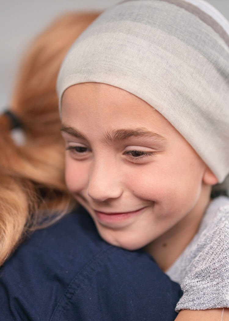 Girl with headscarf smiling and hugging healthcare worker